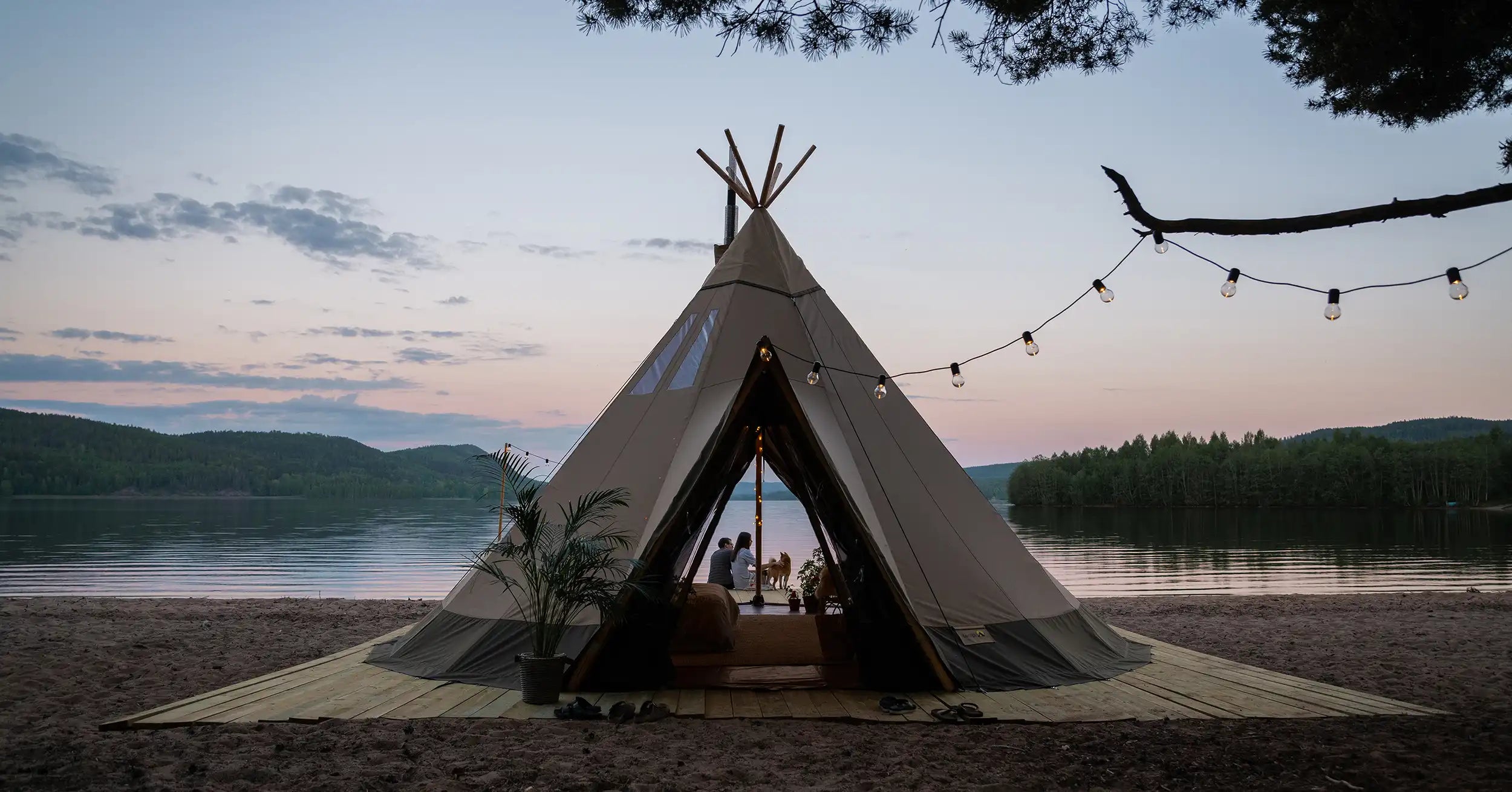 Glamping canvas tent Tentipi Aurum with wood burning stove on a beach by a lake
