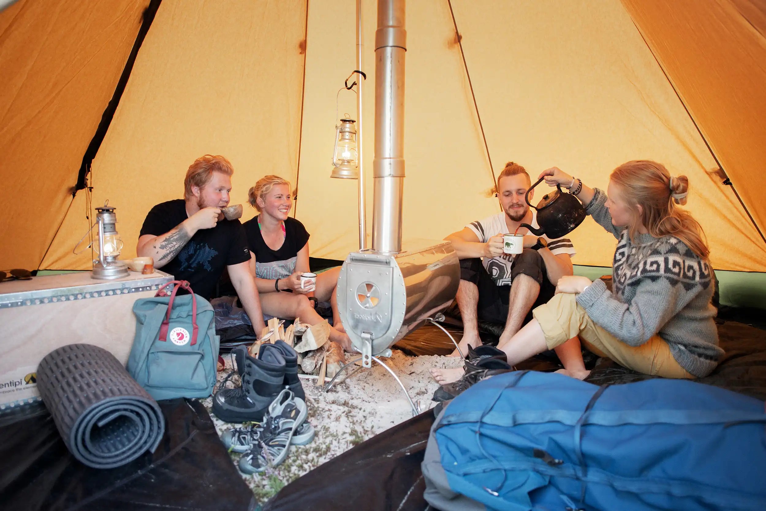 Canvas tent with wood burning stove friends enjoying coffee