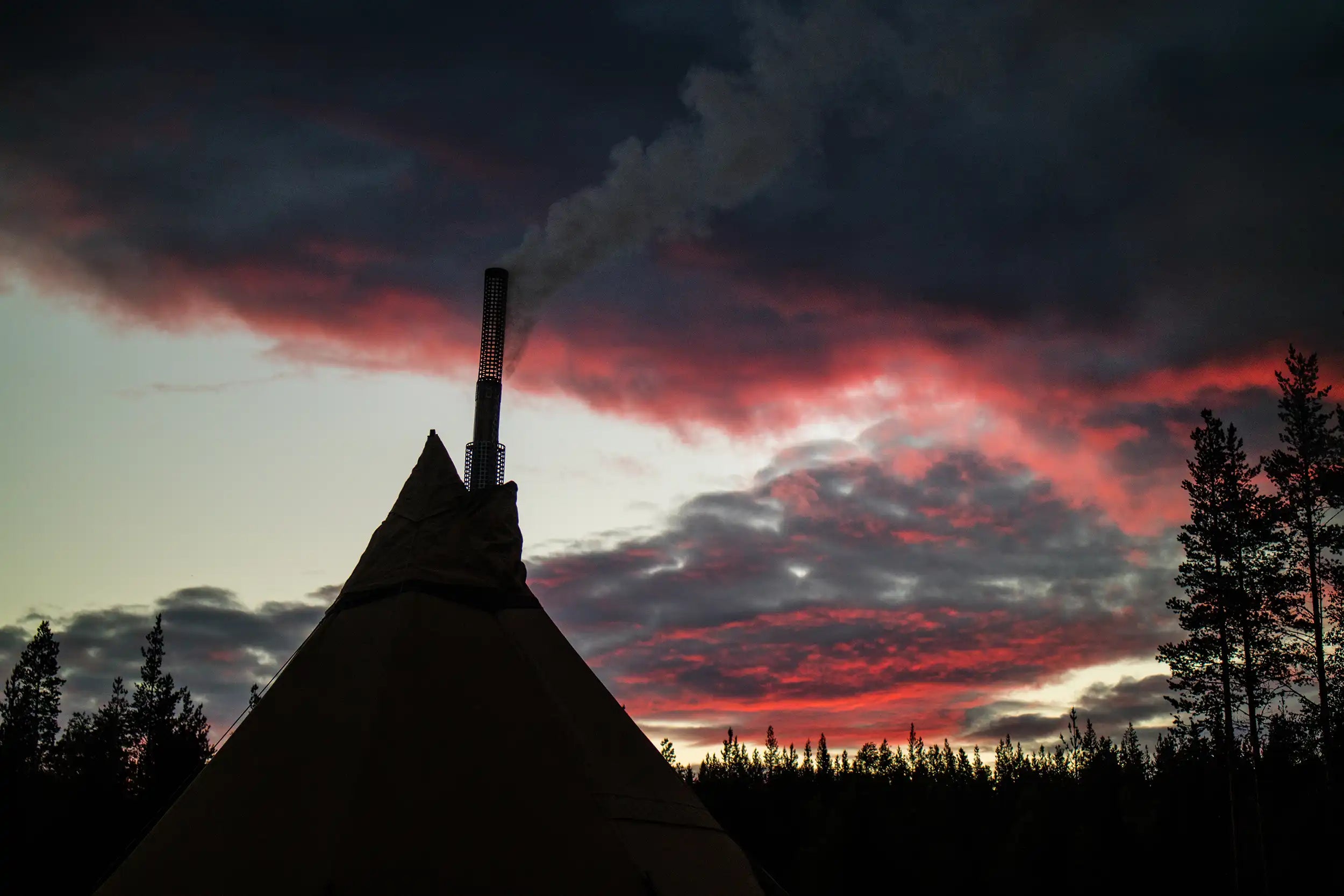 Hot tent camping evening sky with smoke from the tent stove chimney