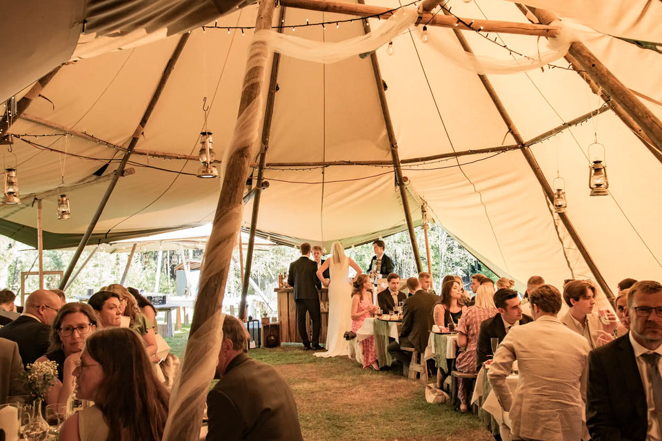 Wedding couple during celebration in large canvas tents