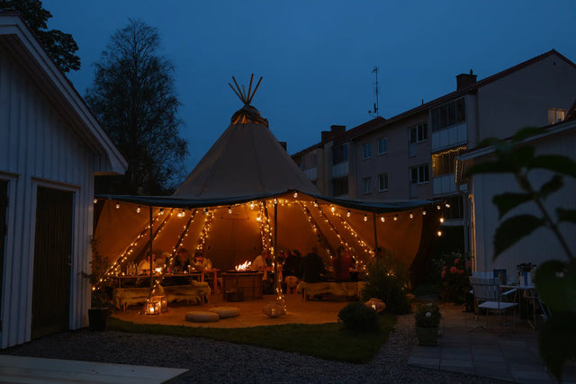 Evening party in Tentipi Stratus 40 canvas Nordic tipi with raised walls in the back garden
